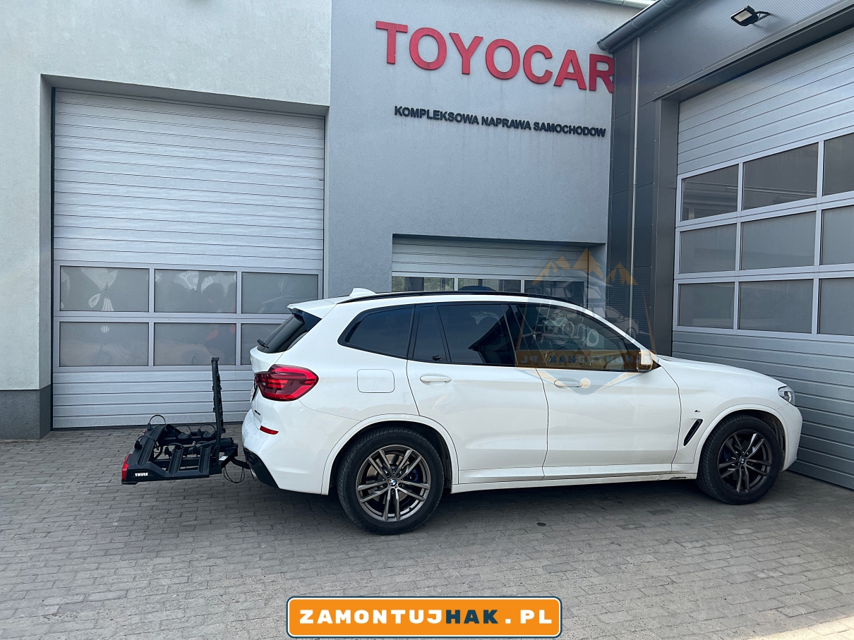 zdjecie auta bmw x3 g01 na tle budynku firmy zamontujahk z bagaznikiem thule 939 black